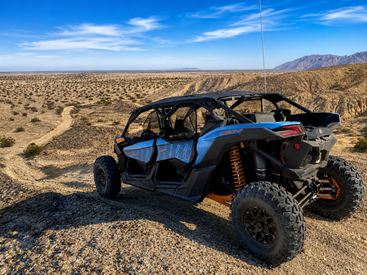 Off-road vehicle on rocky desert terrain under blue sky.